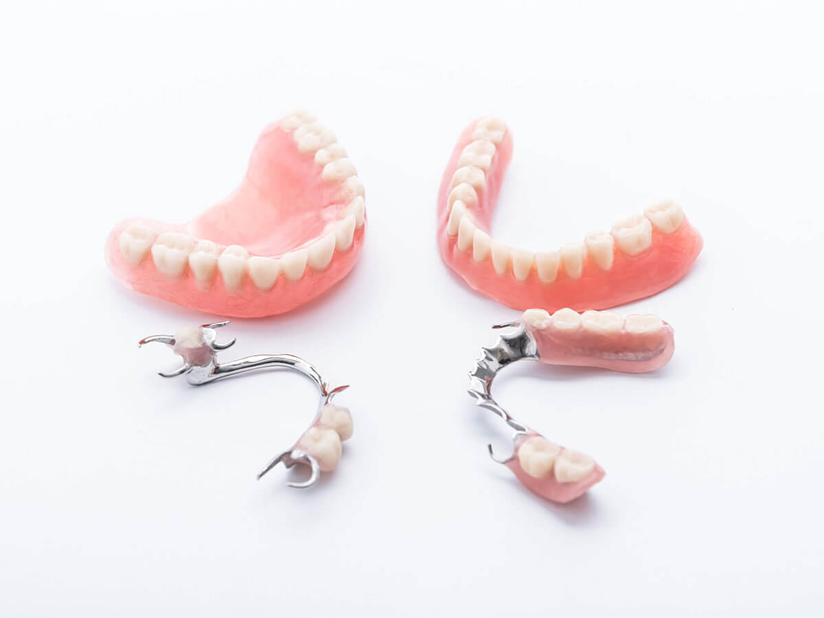 Full and partial dentures on white backdrop