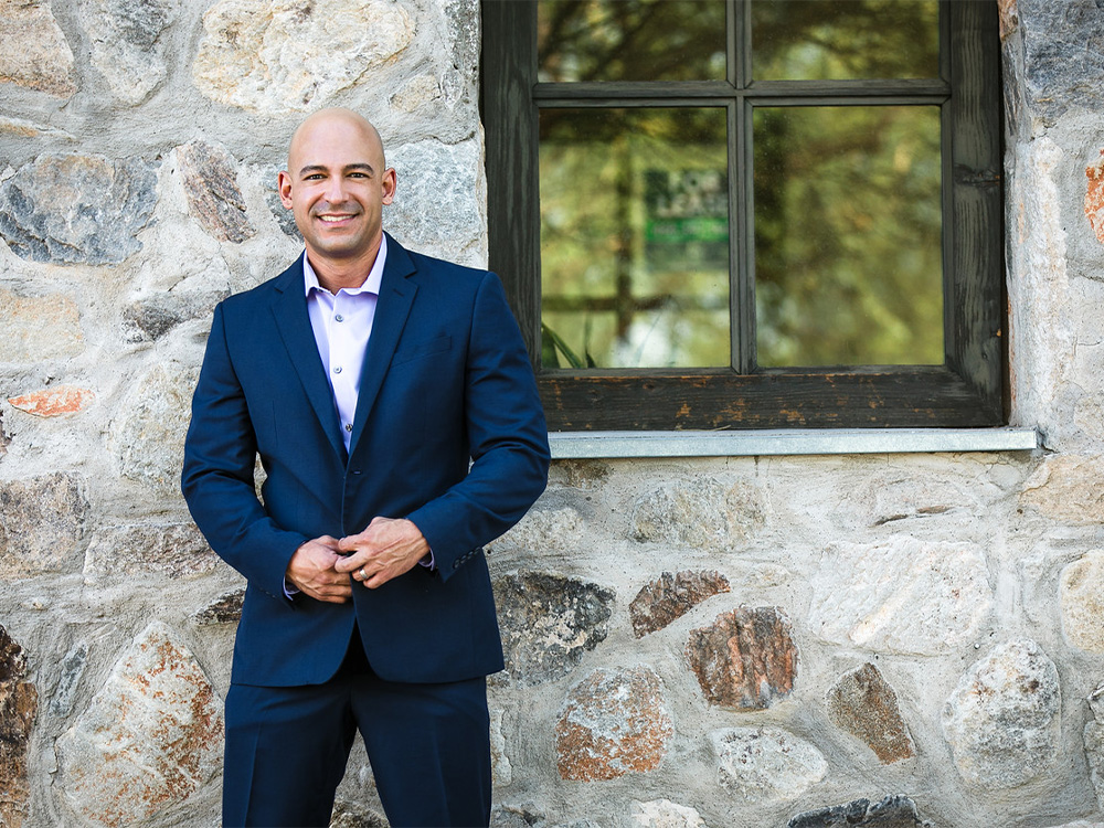 Dr. Jaime Tobon standing in front of a stone building