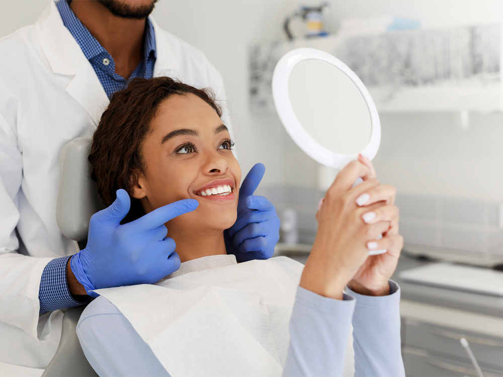 Patient looking at their new smile in mirror