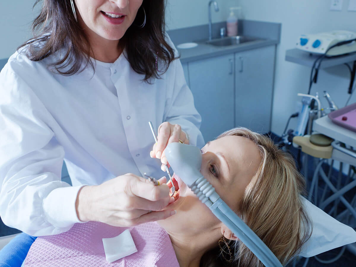 Dentist completing a dental procedure while patient is under sedation